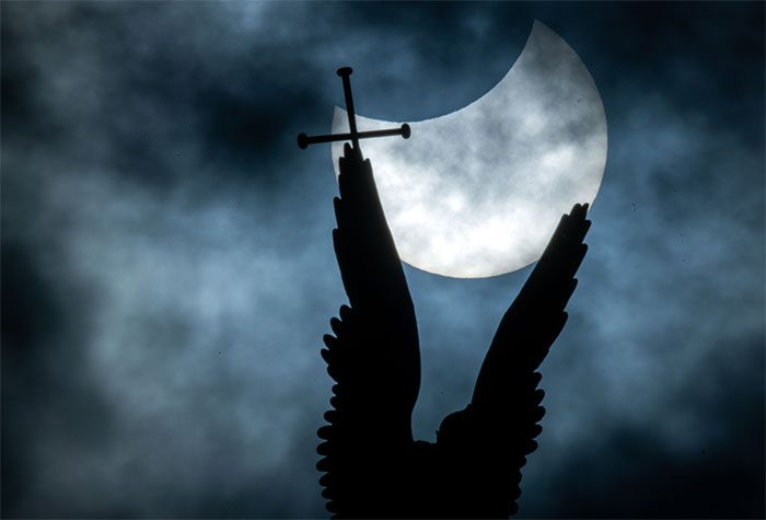 Partial solar eclipse seen above the statue of Archangel Michael