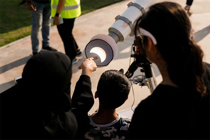 People in Dubai observe the eclipse on October 25 through telescopes.