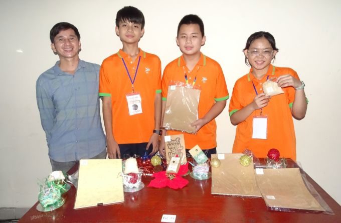 Three team members and teacher Phan Duy Hiep (left) introduce paper made from durian peels