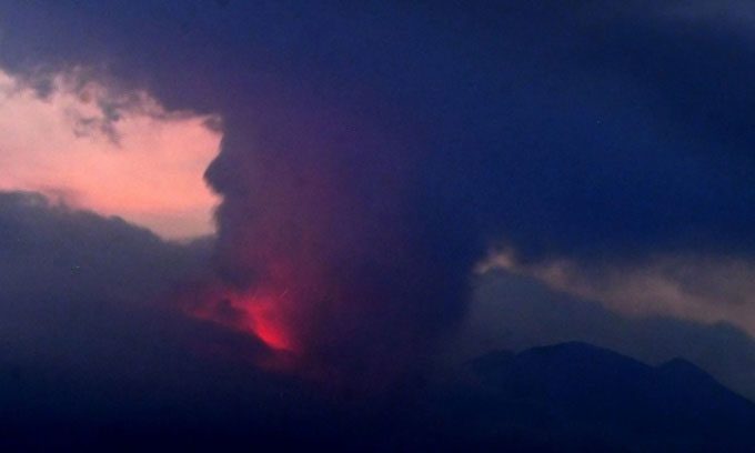 Smoke rises and red lava flows from the mouth of Sakurajima Volcano