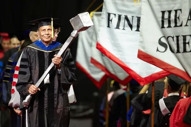 The president holding the scepter at the University of Nevada graduation.