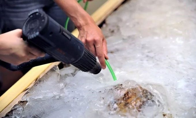 Researchers thawing the 1,300-year-old remains of a child from the 7th century.