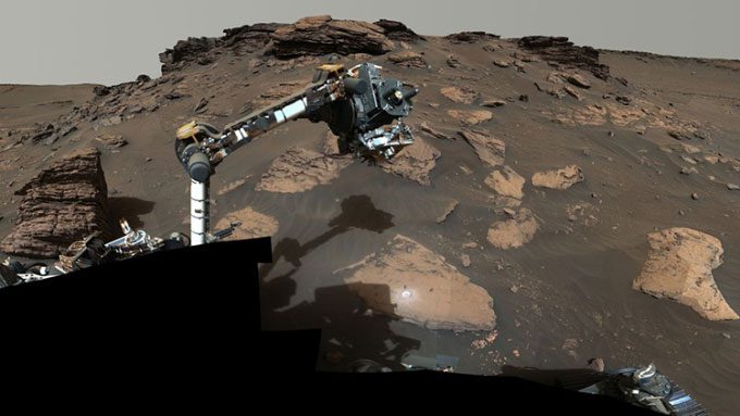 Perseverance using its robotic arm to examine the Skinner Ridge outcrop.