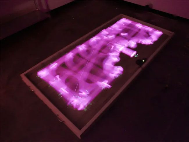 The path of the iRobot Roomba 980 vacuum is marked by purple light