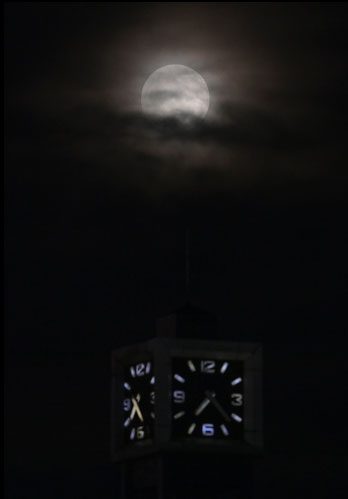 The supermoon viewed from Hoan Kiem Lake through the roof of the Hanoi Post Office clock tower