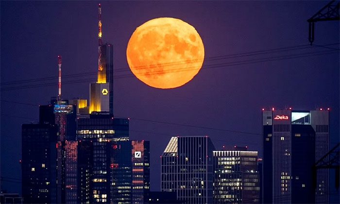 The supermoon hangs behind skyscrapers in the financial district of Frankfurt, Germany.