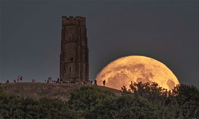 The moon rises behind Glastonbury Tor hill in Somerset, England.