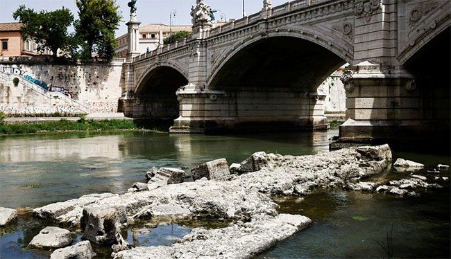 The Tiber River, Rome, reveals the remains of an ancient bridge.