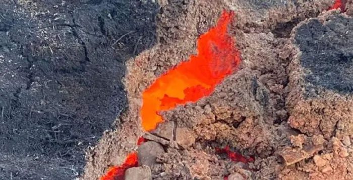 "The cracked, glowing rock is red-hot and billowing smoke"
