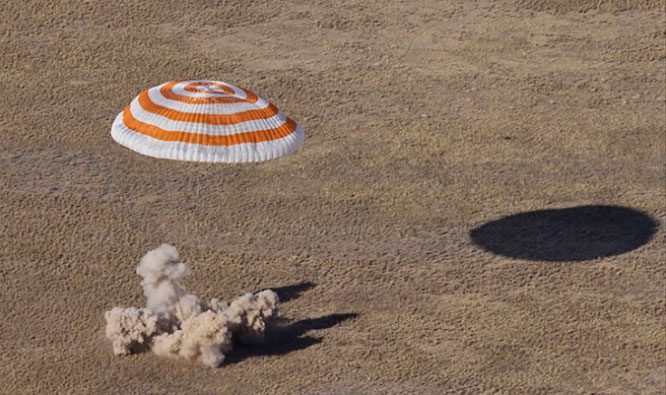 Soyuz MS-21 spacecraft landing with parachutes on a steppe in Kazakhstan.