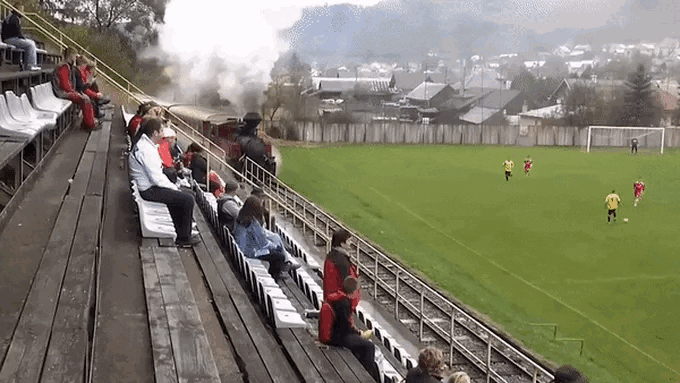 A train passes by during a football match.
