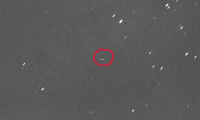 NASA's Orion spacecraft appears as a small dot (marked by an arrow) in the center of the photo.