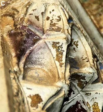 Damaged gold-plated tin with purple patches.