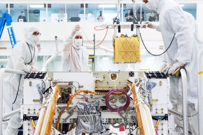 A member of NASA's Mars 2020 project installs MOXIE onto the Perseverance frame.