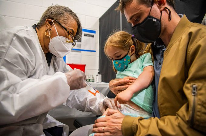A two-year-old girl receiving a Moderna vaccine in Times Square, USA