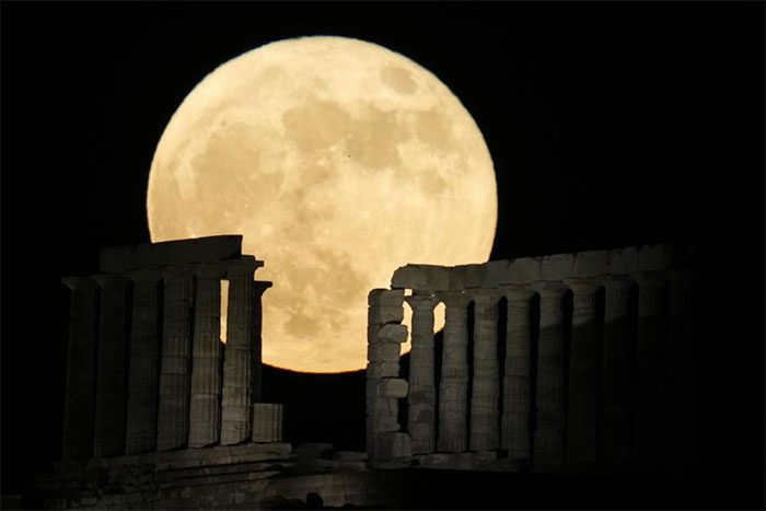 The moon illuminating the columns of the ancient Temple of Poseidon at Cape Sounion (Greece).