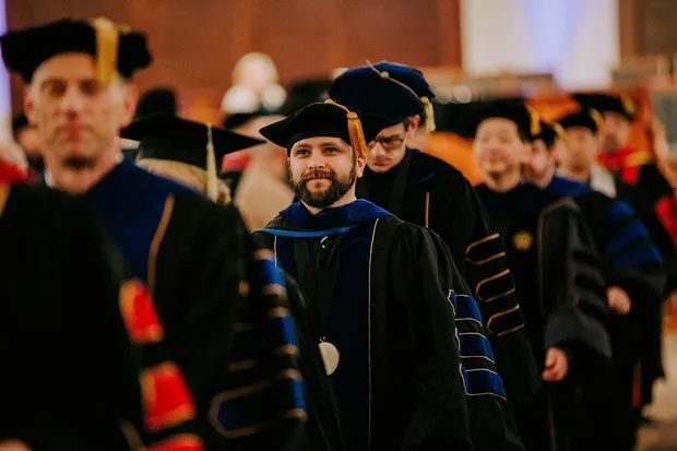 Academic regalia with different colors based on degree.