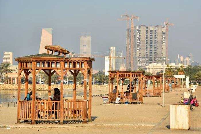 People seeking shade in a gazebo on Shuwaikh beach in Kuwait City.