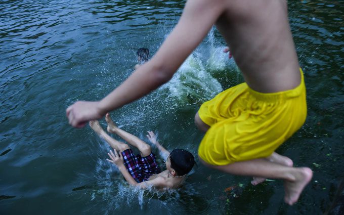 Children in suburban Hanoi cooling off in the village pond, summer 2020.