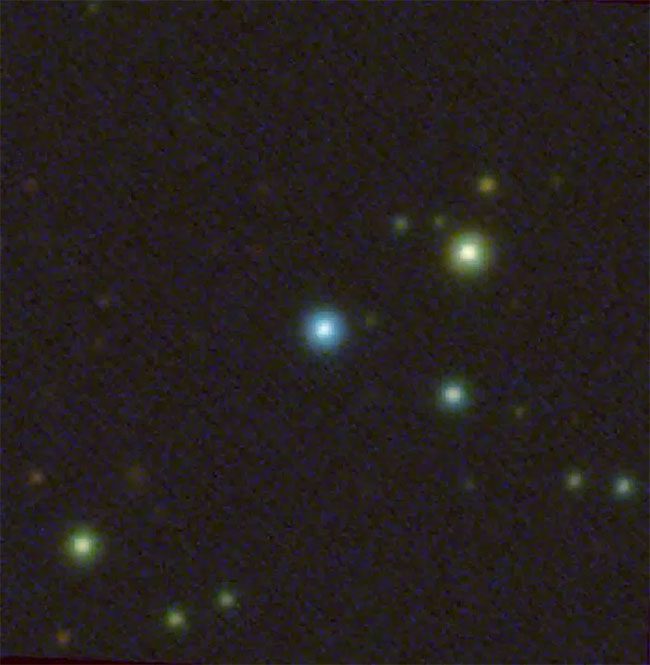 Image showing the growing black hole as a source of blue light.