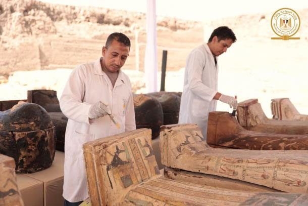 Scientists restoring some coffins before the exhibition.