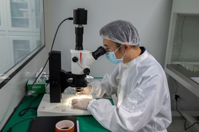 Researcher Yang Wei observes a lunar soil sample under a microscope.