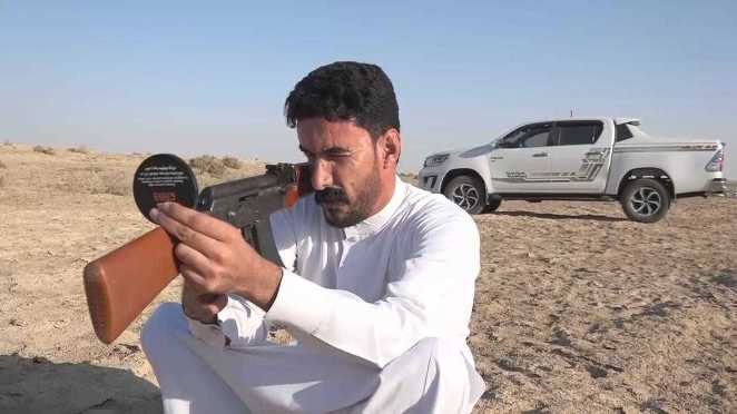 Fadel Abu Duha using an AK-47 rifle