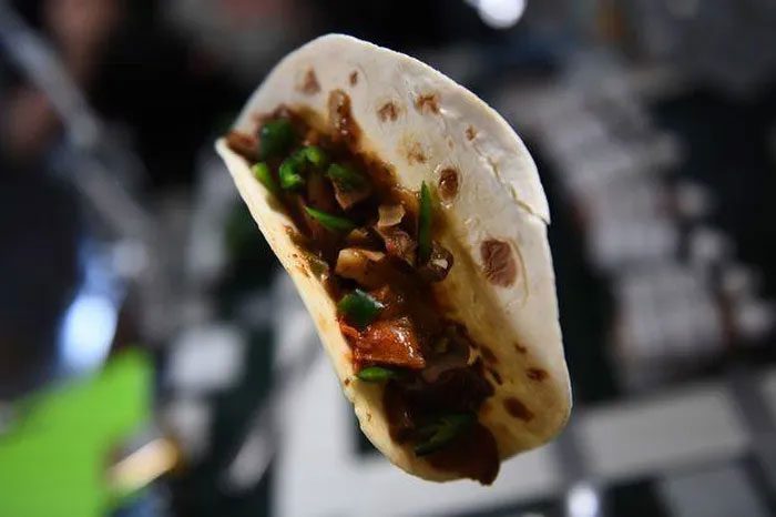 Astronaut making tacos from successfully grown peppers on the International Space Station.