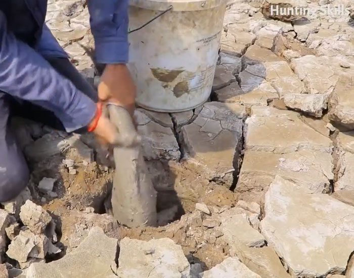 The man easily catches fish hiding in the ground.