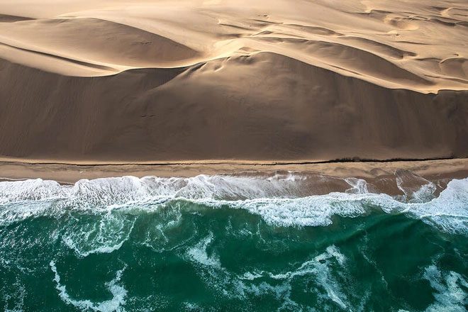 Skeleton Coast is a landscape of desert sand interspersed with rocky outcrops