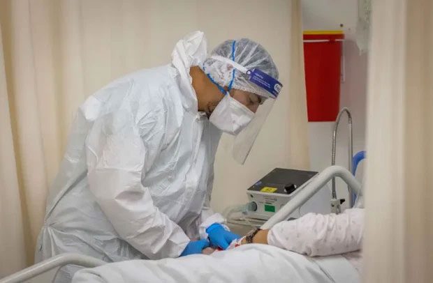Healthcare workers in protective gear caring for Covid-19 patients