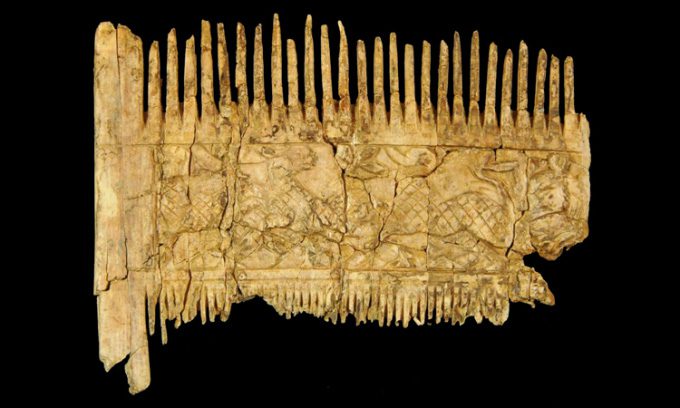 The ivory comb with intricate animal carvings.