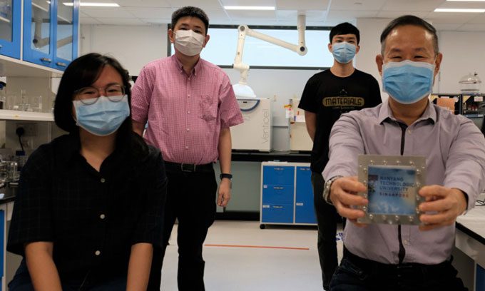 Research team at Nanyang Technological University with a window sample incorporating the new material.