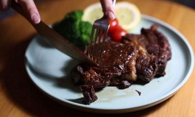 Researchers using wooden knives to cut steak.