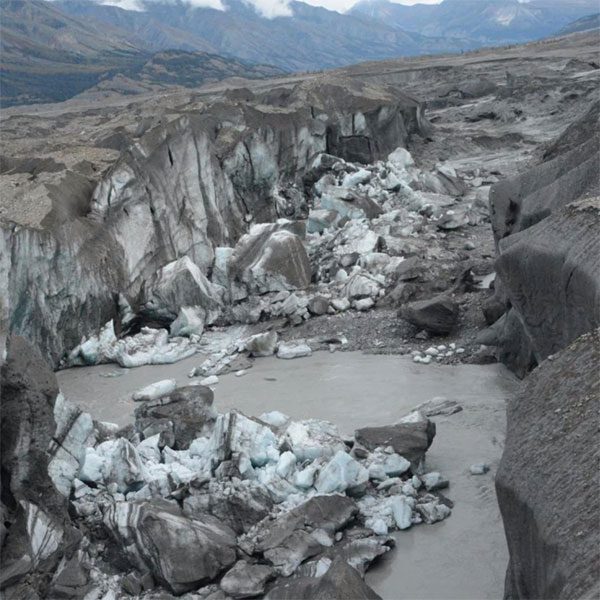 The canyon with ice walls at the end of the Kaskawulsh Glacier, with newly collapsed ice blocks.