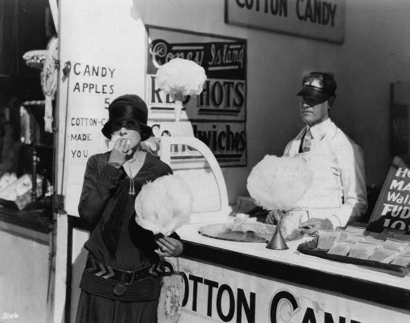 A young girl eating cotton candy.
