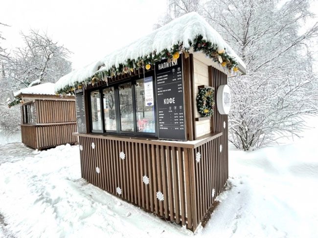 A café selling hot drinks in the park with a "snow" roof.