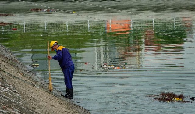 A worker from Hanoi's drainage company collects trash from the Tô Lịch River on October 13.