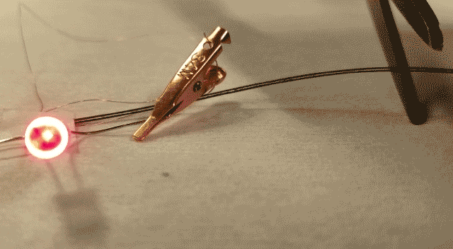 The fiber battery continues to power an LED even after a section is cut off