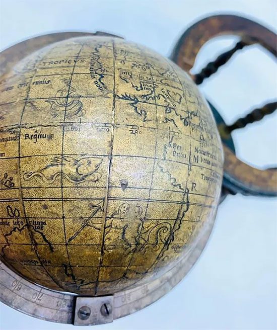 Jim Spencer poses next to the 16th-century globe.