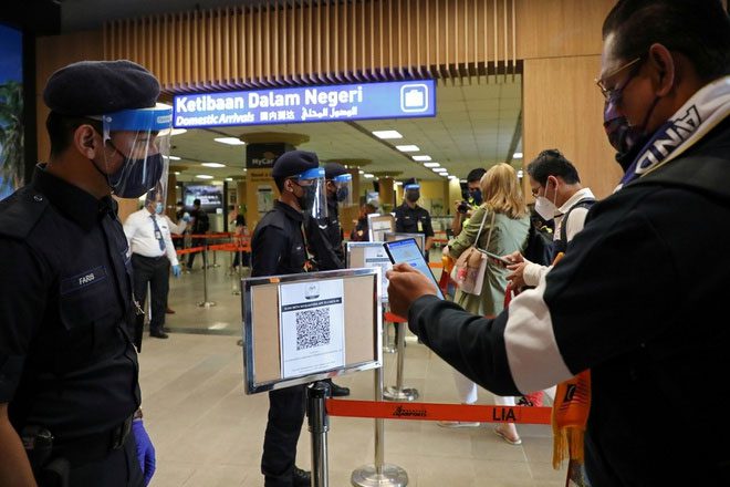A traveler scans a QR code to check in upon arriving at the airport in Langkawi