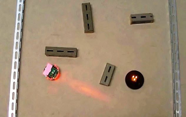 The robot is placed on a surface with obstacles and moves toward its target.