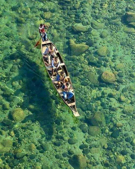 The water is so clear that the riverbed is visible.