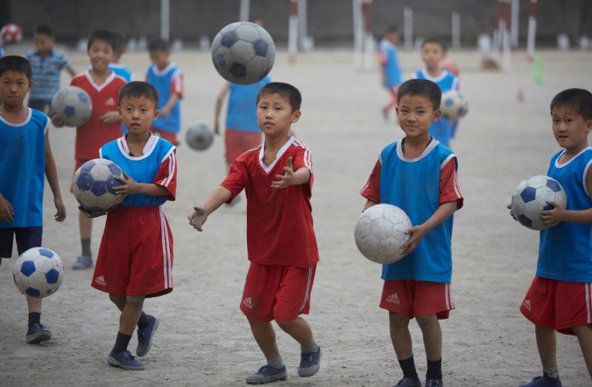 Boys playing soccer at a school in Pyongsong.