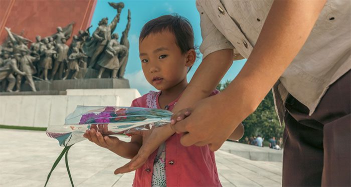 A girl is taken by her mother to visit the Grand Monument on Mansudae Hill, Pyongyang.