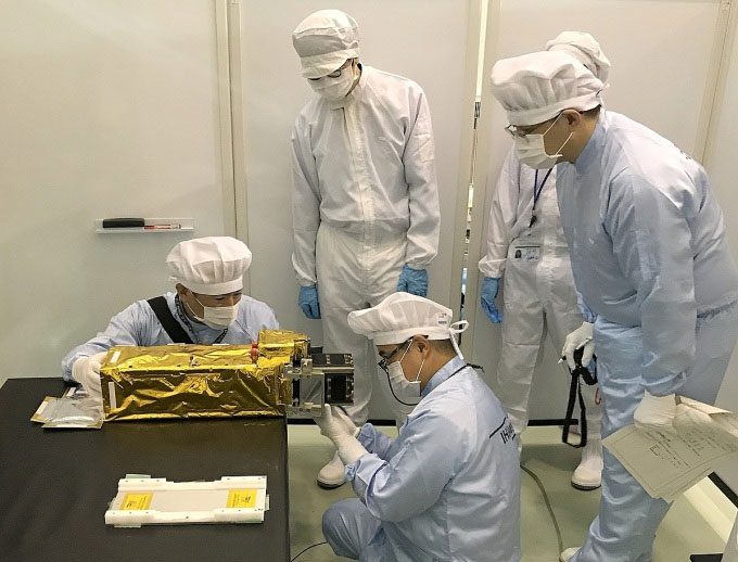 Japanese experts inspecting the NanoDragon satellite during handover on August 17.
